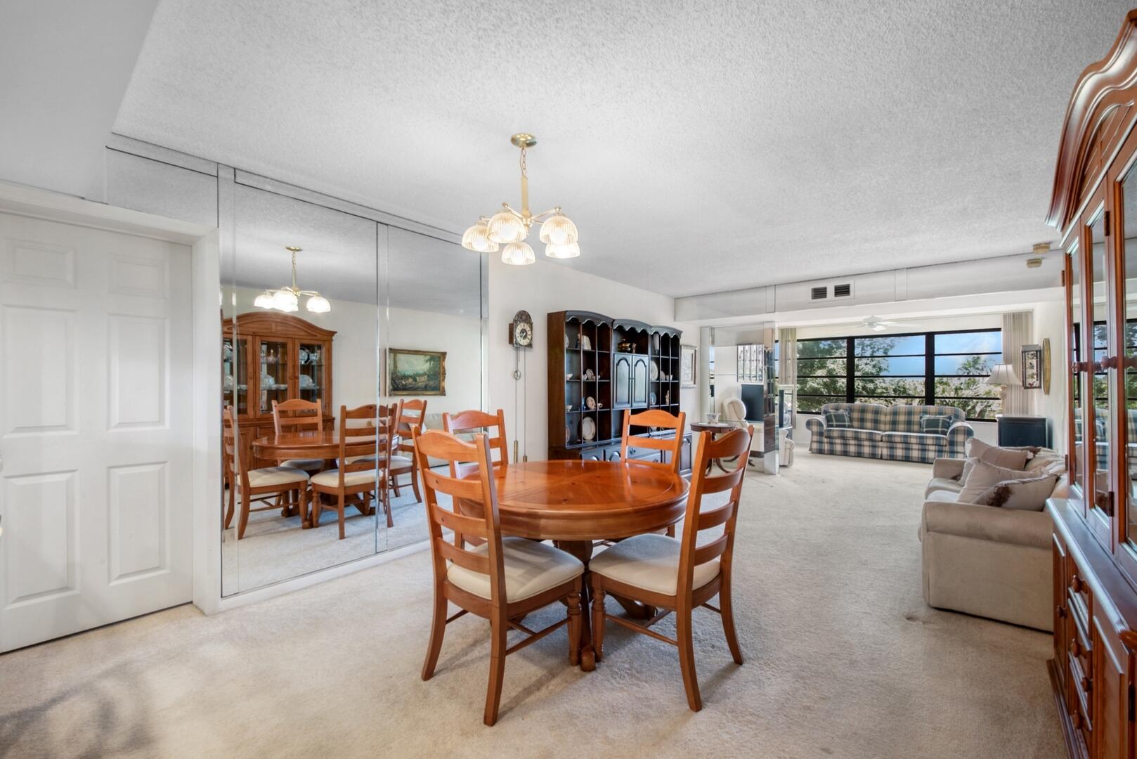 a dining room with furniture a chandelier and window