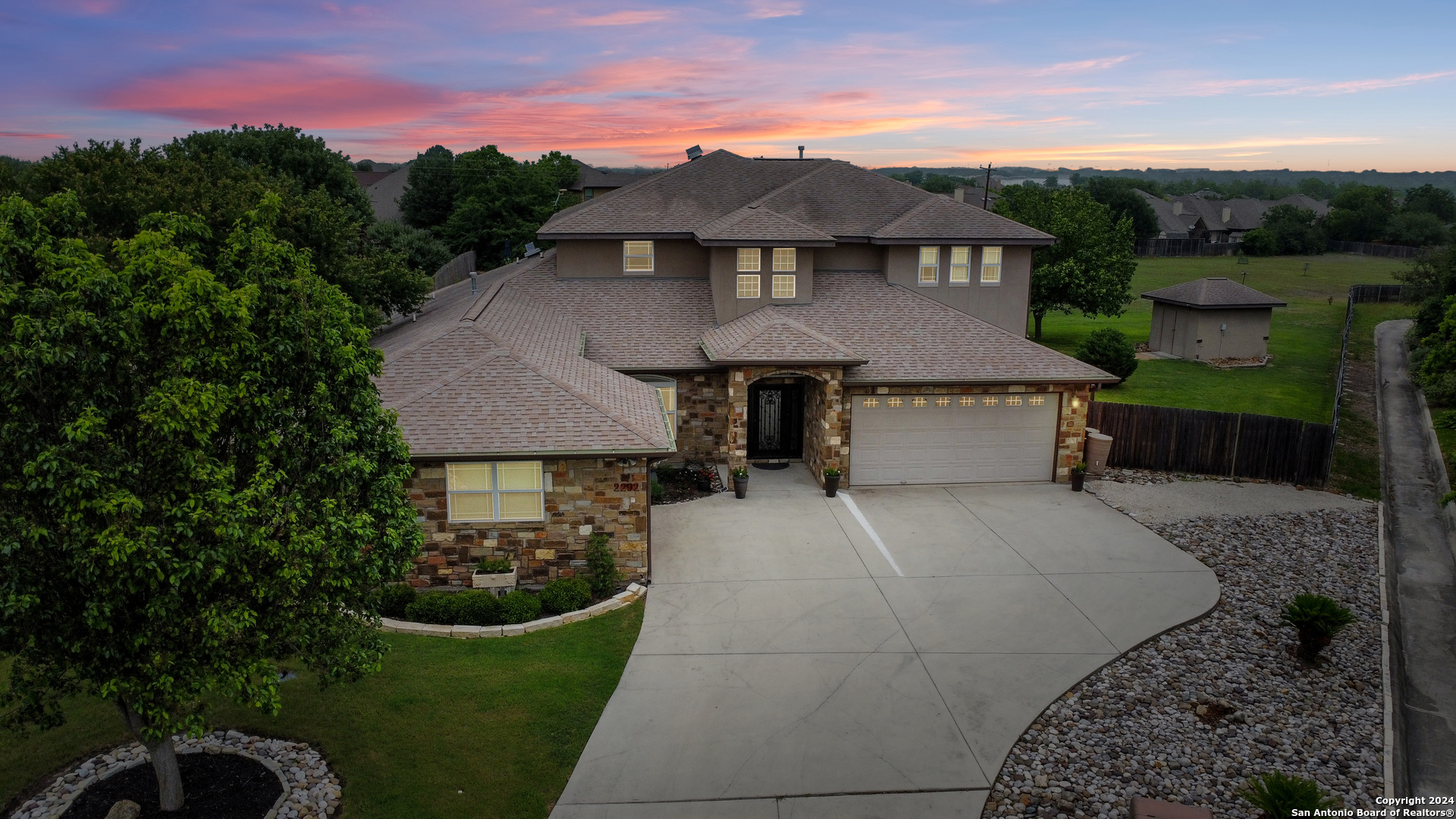 a aerial view of a house with a yard plants and large tree