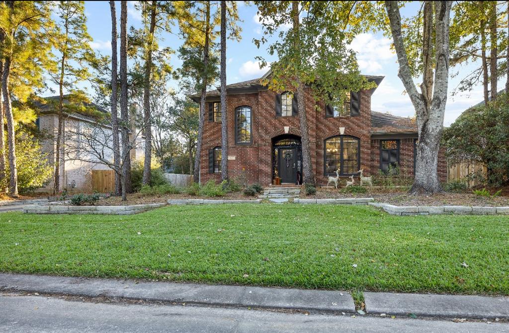 a front view of a house with a garden and a tree