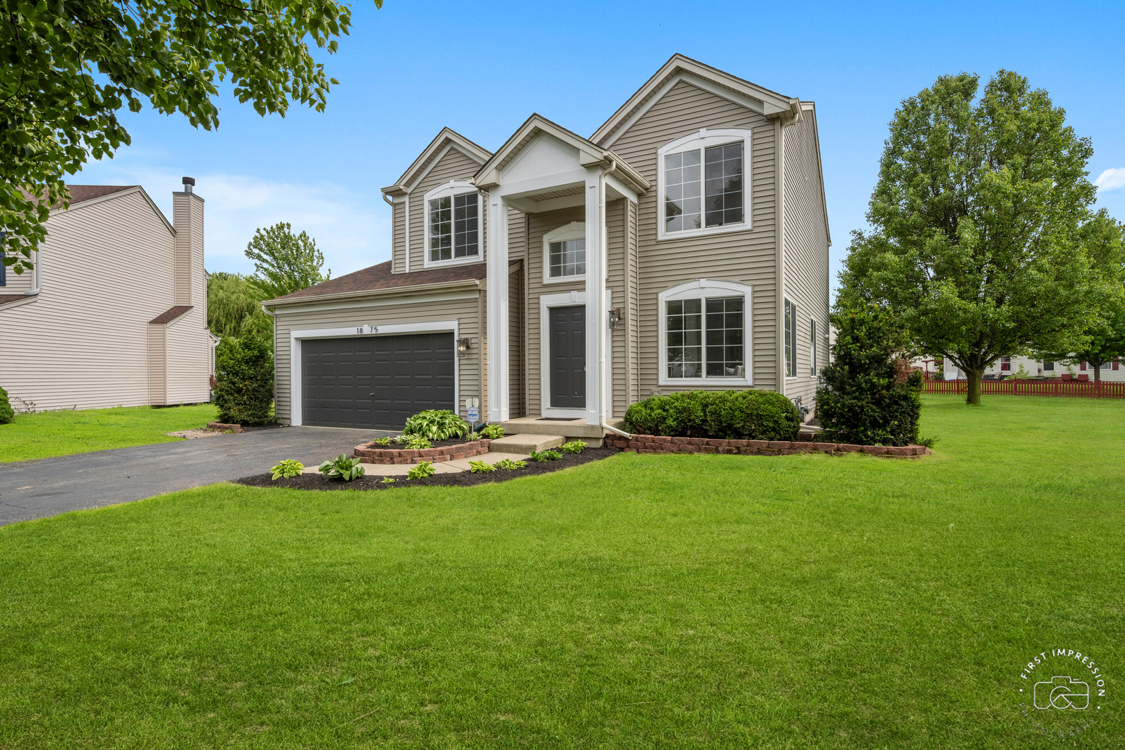 a front view of a house with a garden and yard