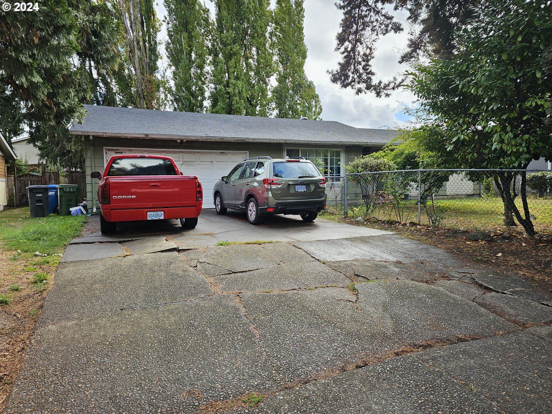 a front view of a house with a garden and parking space