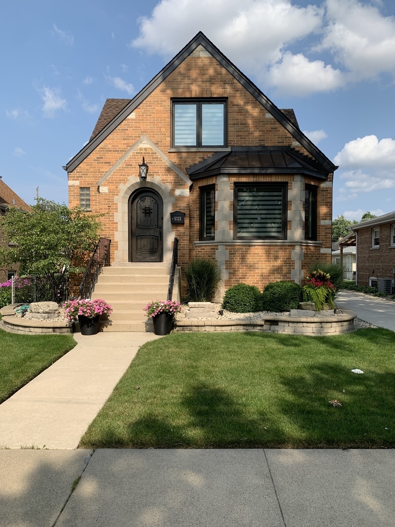 a front view of a house with a garden and plants