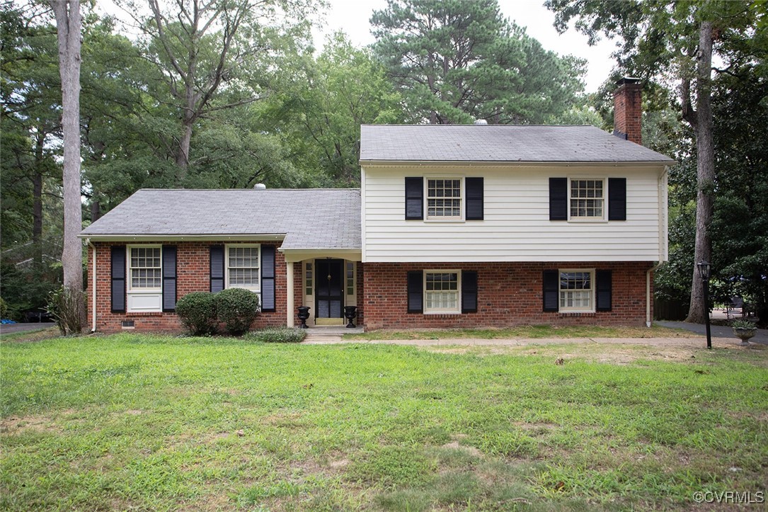 a front view of a house with yard and trees