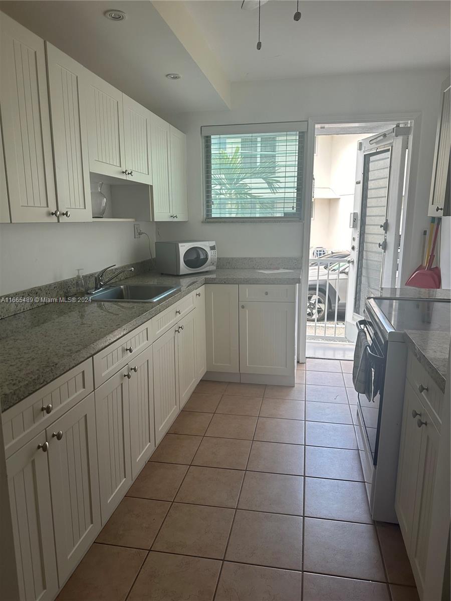 a kitchen with a sink a stove and cabinets