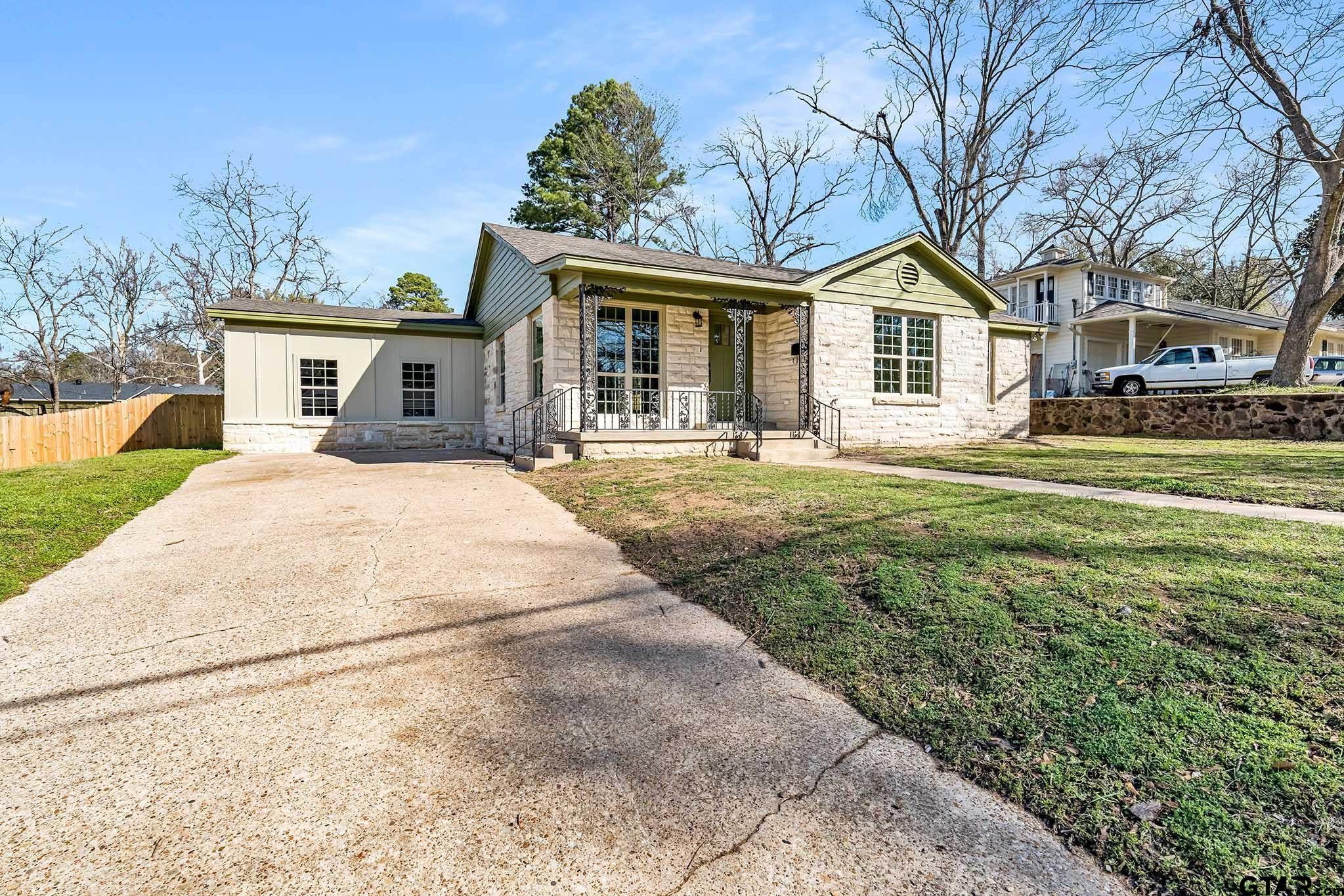 a front view of a house with a yard outdoor seating and garage