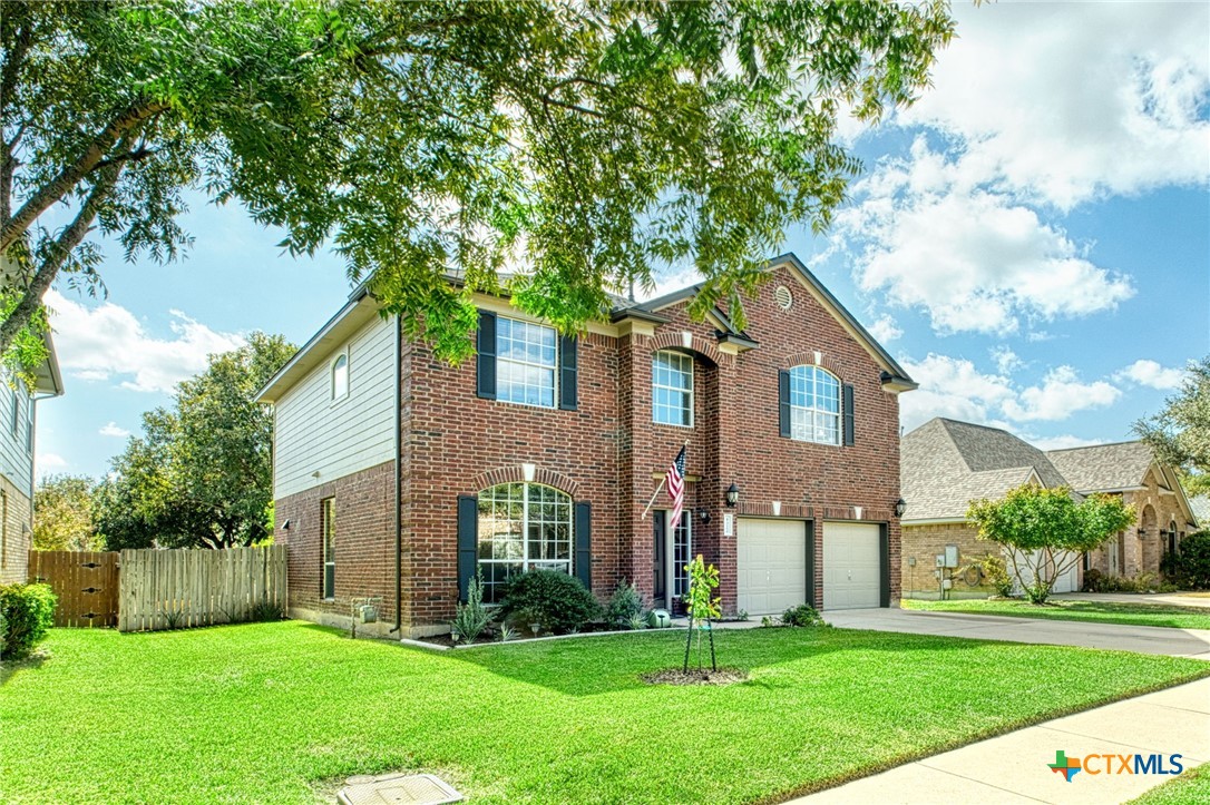 a front view of a house with a yard and trees