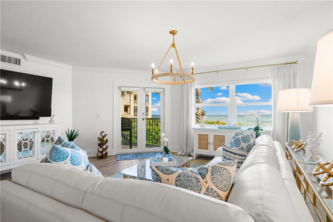 a living room with furniture a flat screen tv and a large window