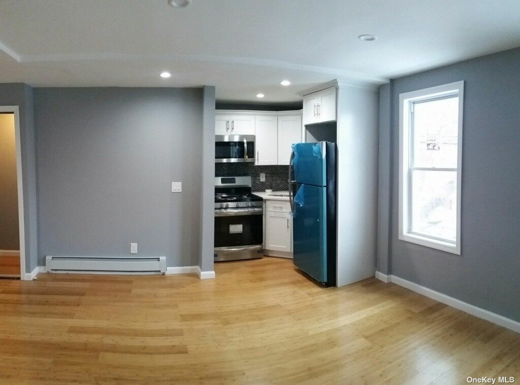 a view of kitchen with refrigerator and window