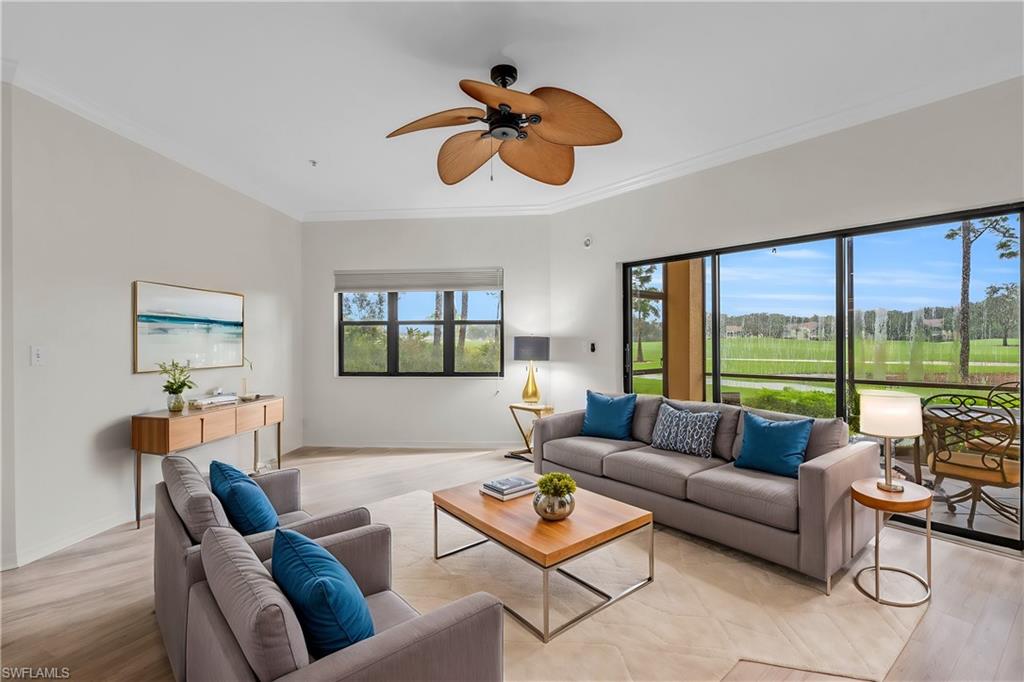 a living room with furniture ceiling fan and a large window