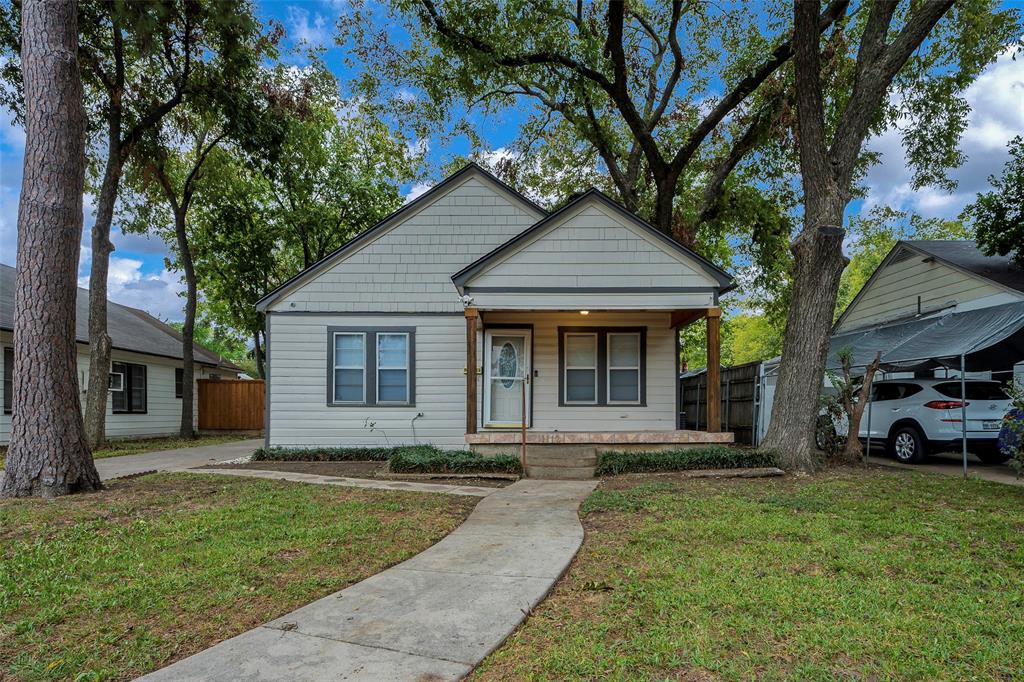 a front view of a house with a yard and trees