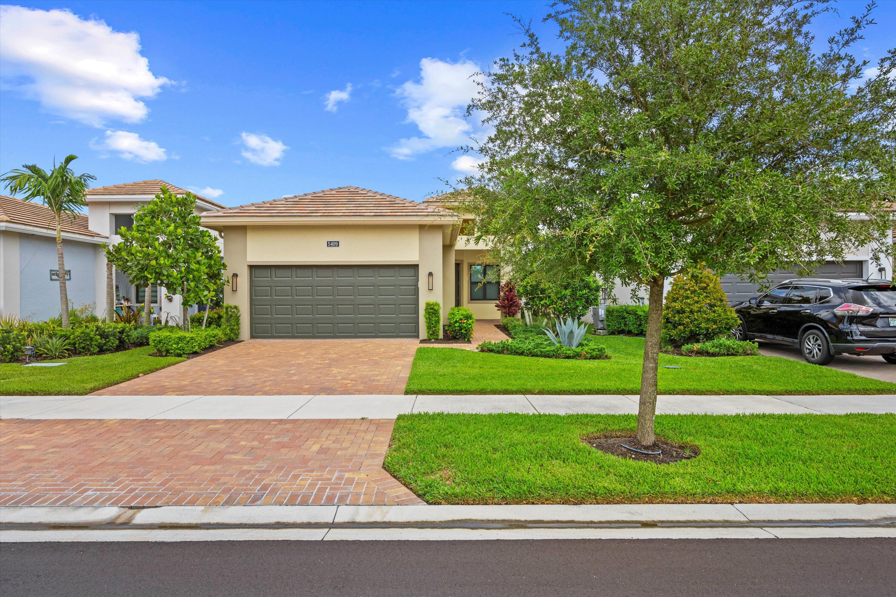 a front view of a house with a yard and garage