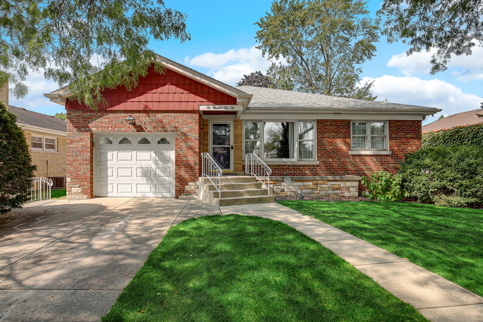 a front view of a house with a garden and yard