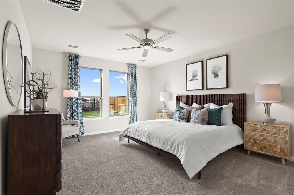 a bedroom with a large bed and a chandelier fan