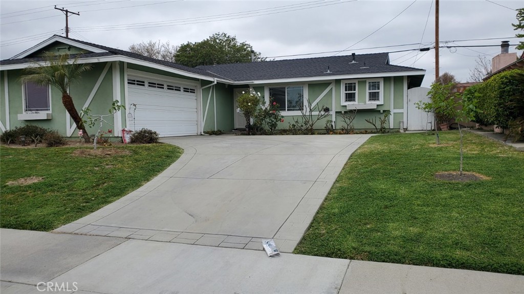 a front view of a house with a yard and trees