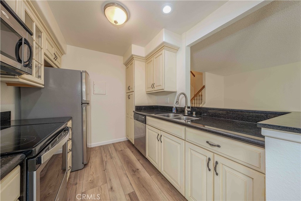 a kitchen with granite countertop a sink stove and cabinets