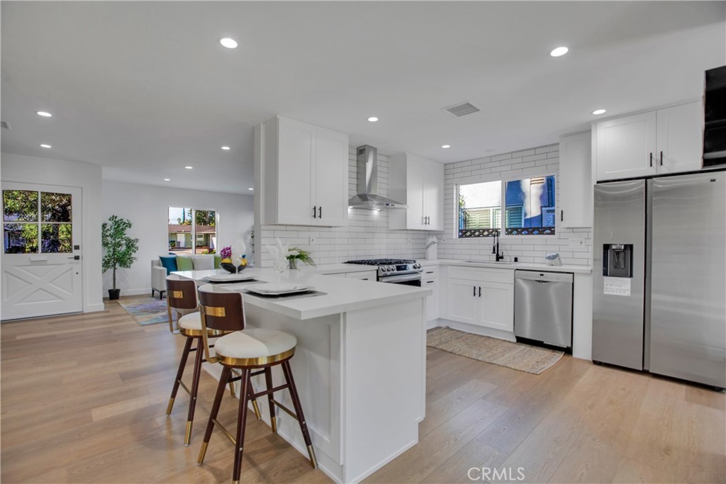 a kitchen with white cabinets and stainless steel appliances