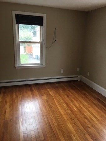 a view of a room with wooden floor and a window