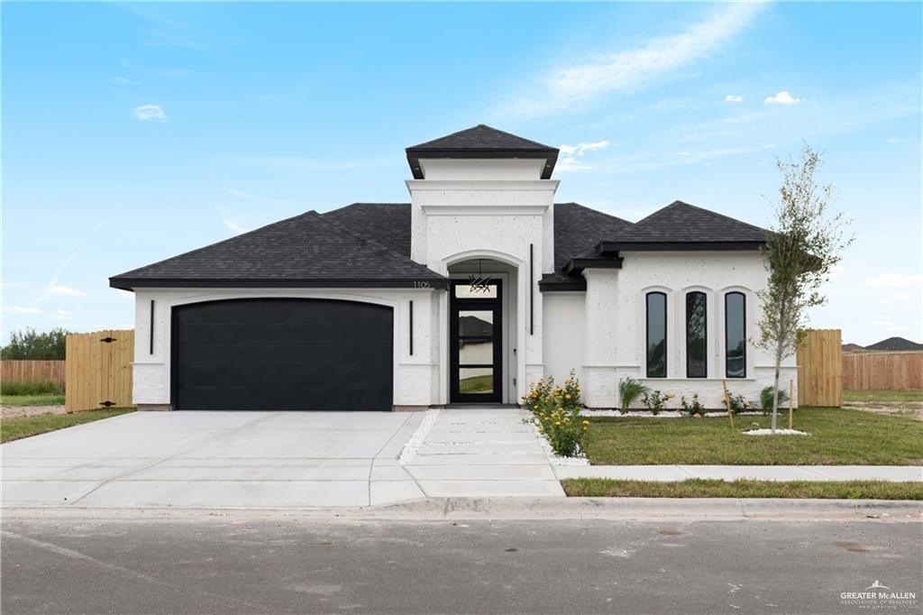 View of front of house with a front yard and a garage