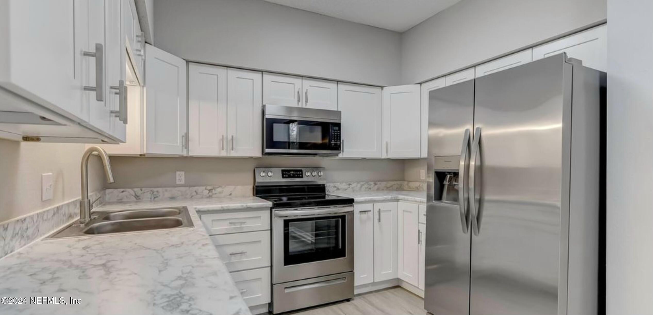 a kitchen with cabinets stainless steel appliances and a counter top space