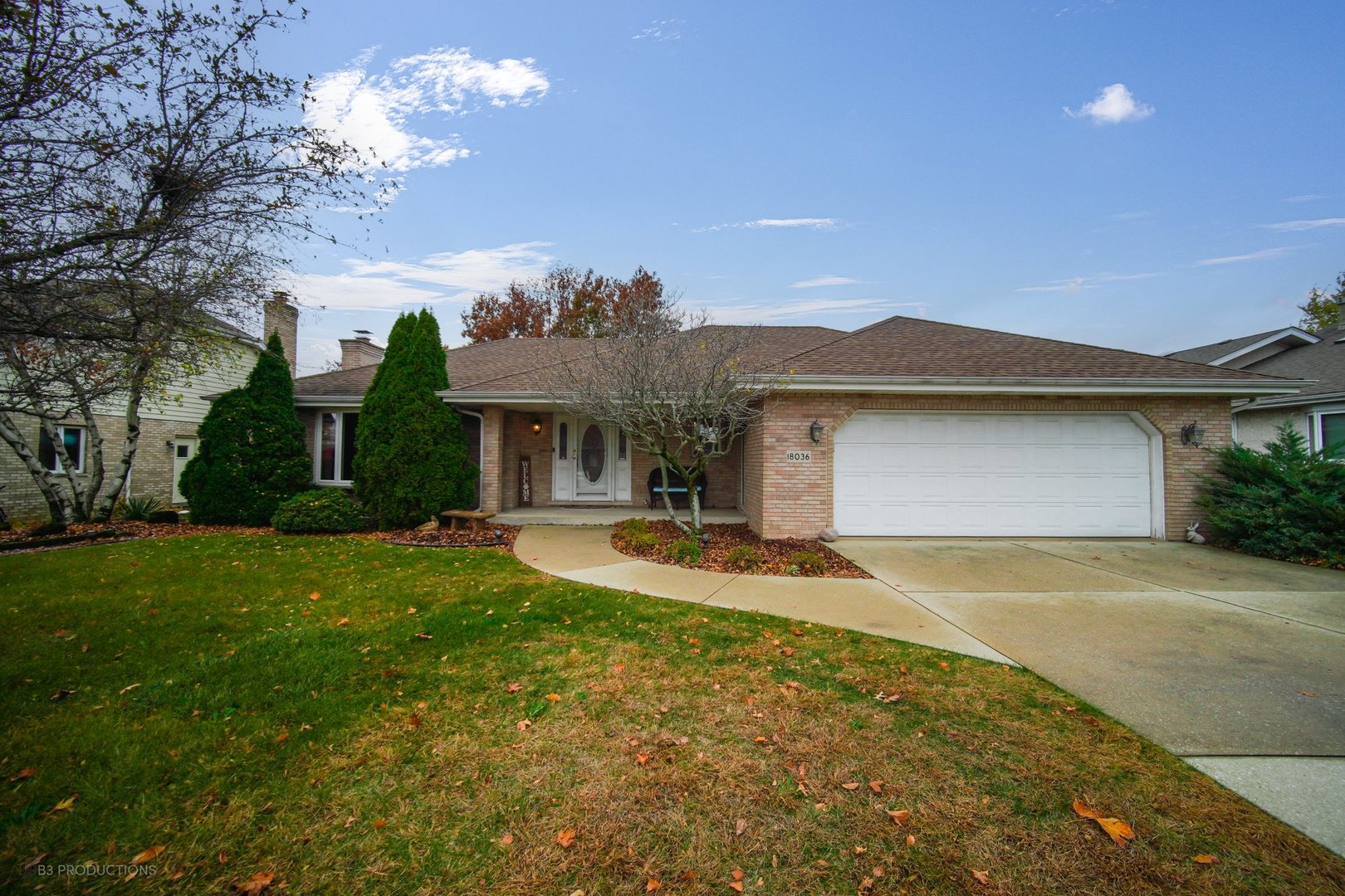 front view of a house with a yard and garage