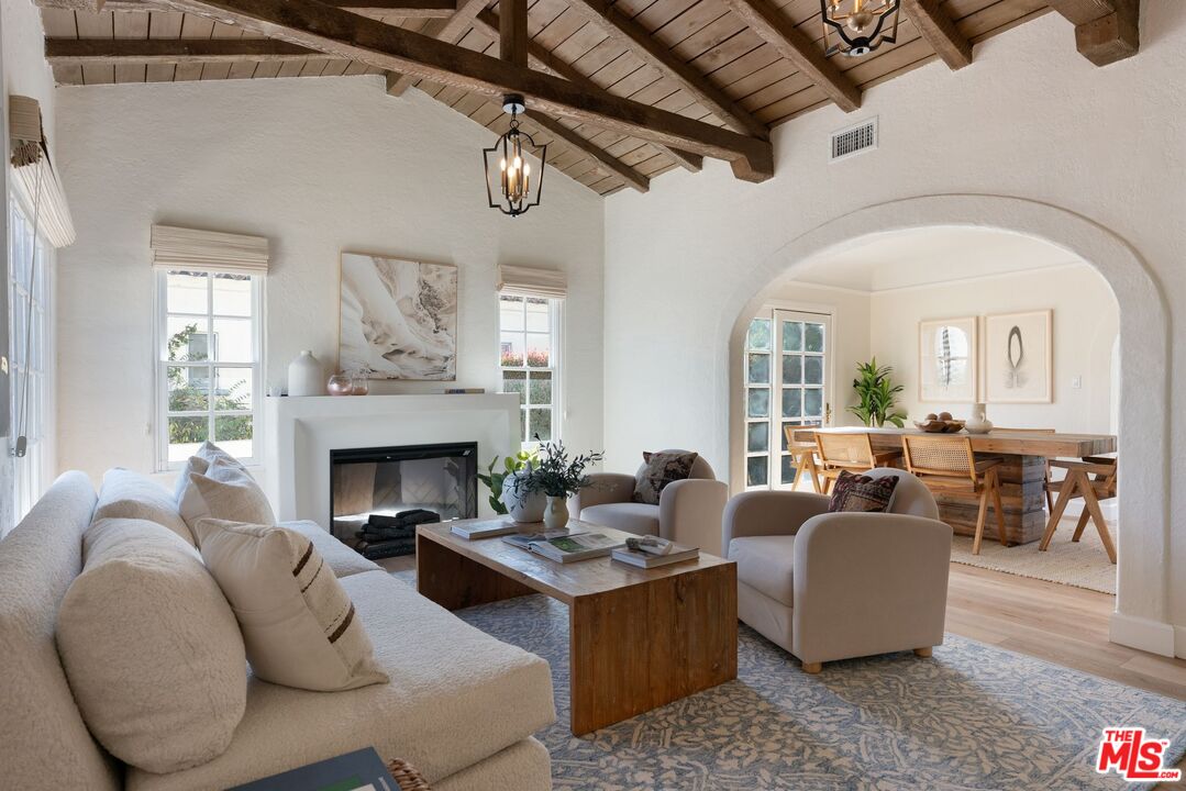 a living room with furniture fireplace and a large window