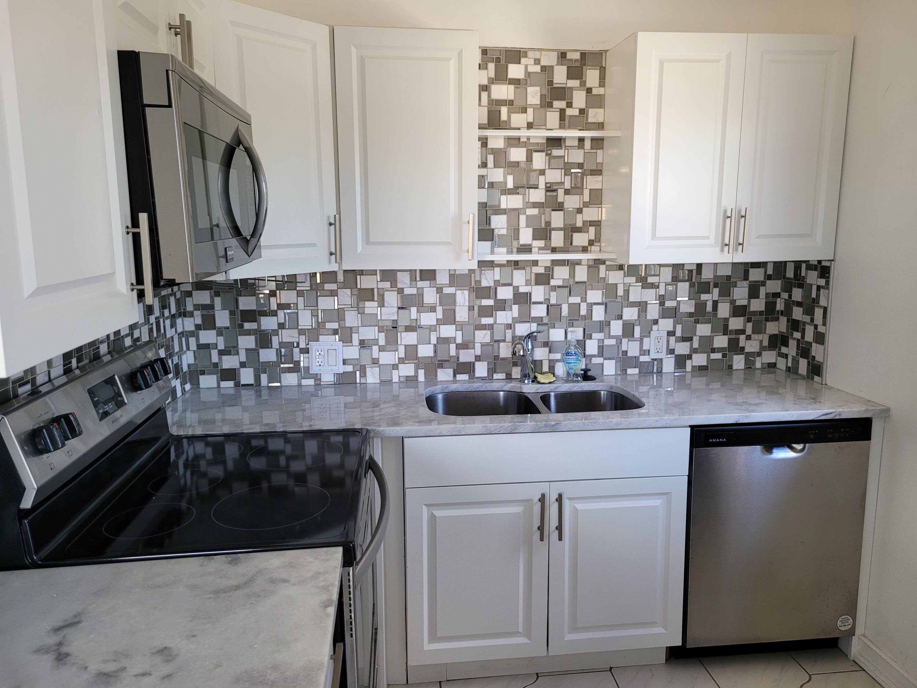 a kitchen with granite countertop white cabinets and a stove