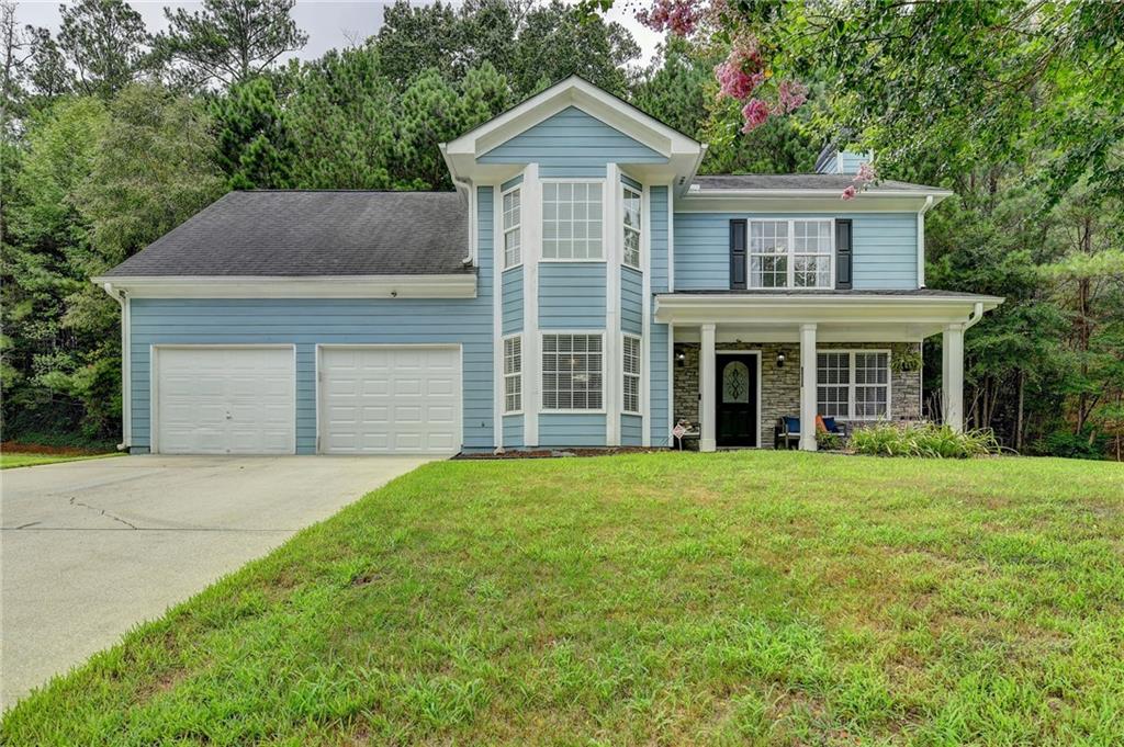 a front view of a house with a garden and yard