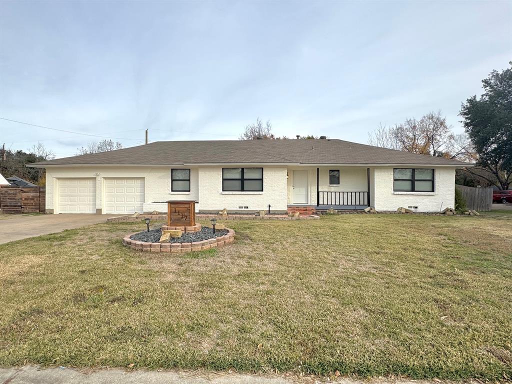 a front view of a house with a yard and seating space