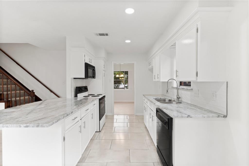 a kitchen with granite countertop a sink stove and cabinets