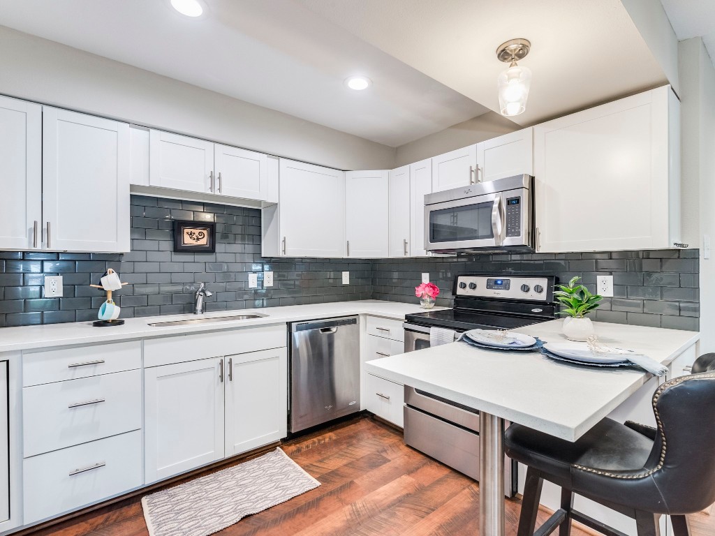 a kitchen with a stove a sink and a microwave