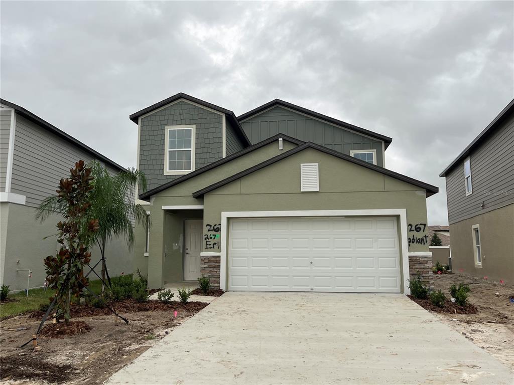 a front view of a house with a yard and garage