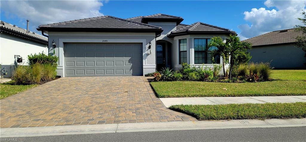 View of front of property with a garage and a front yard