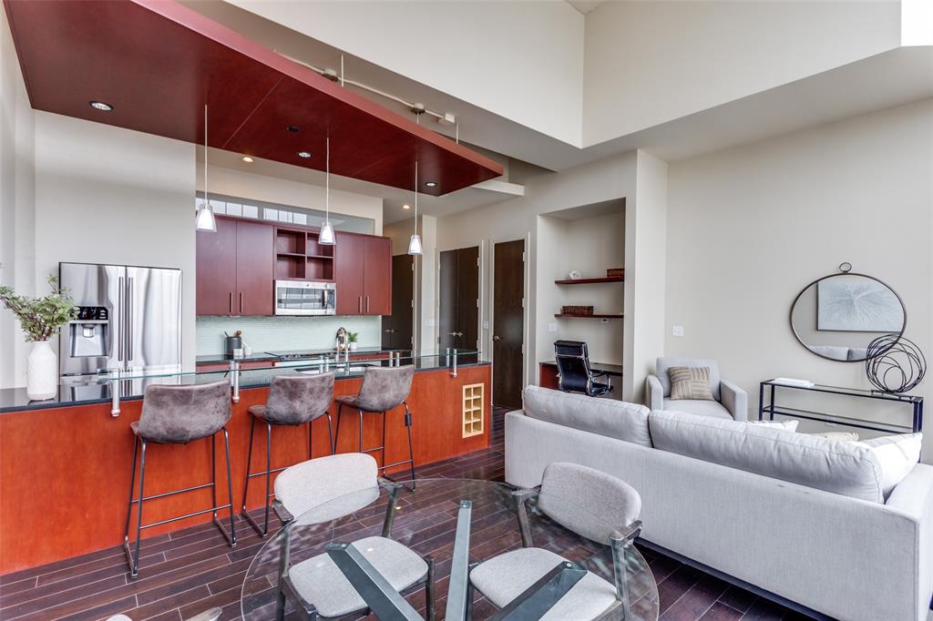 a living room with furniture kitchen view and a large window