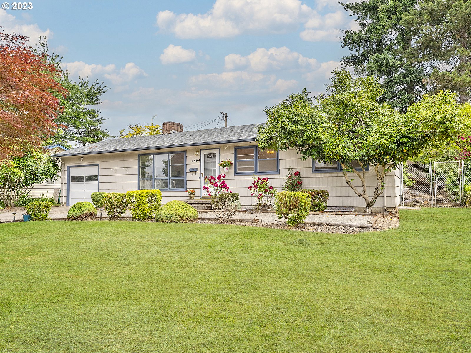 a view of a house with a big yard and sitting area