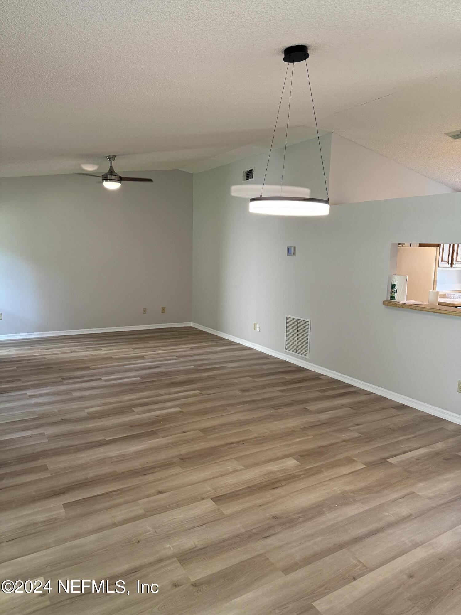 an empty room with wooden floor and white walls