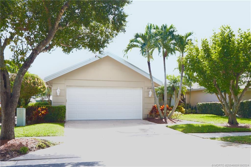 front view of house with a yard and trees around