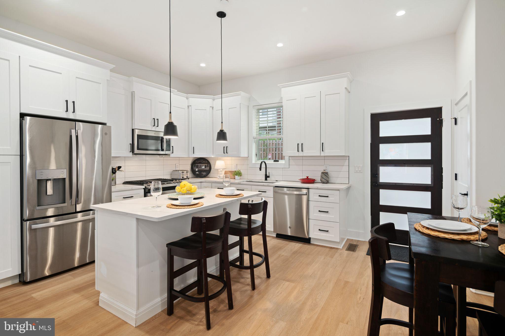 a kitchen with white cabinets and stainless steel appliances