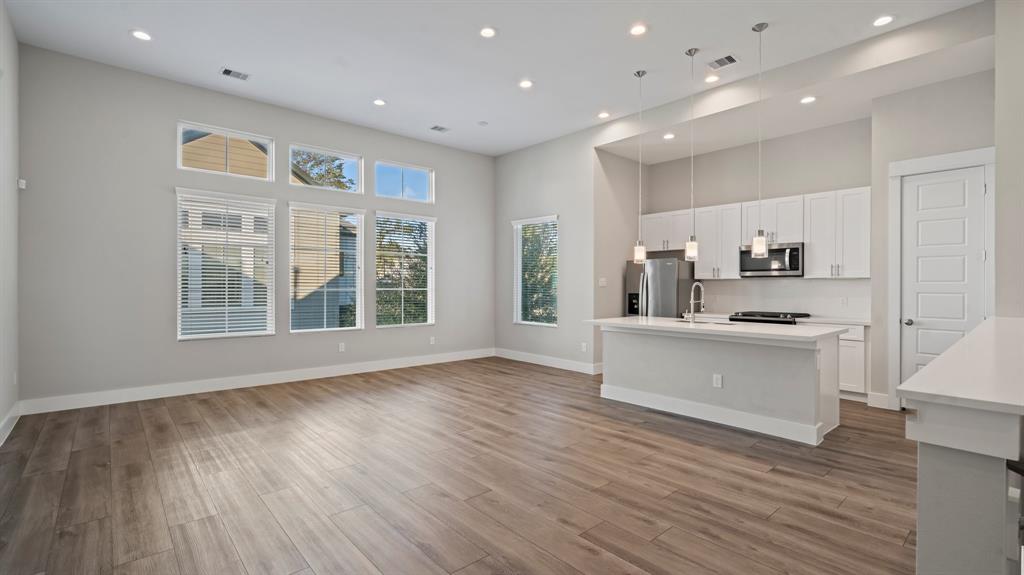 a large kitchen with stainless steel appliances wooden floors and wooden cabinets