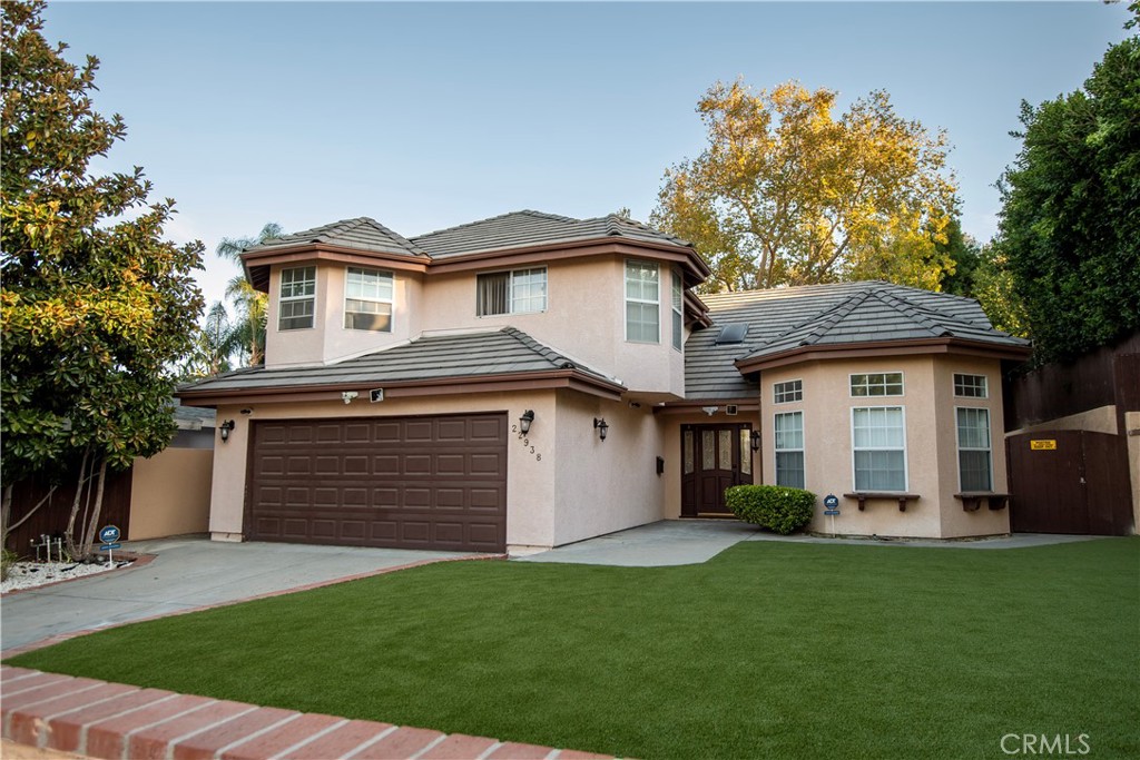 a front view of a house with a garden and plants