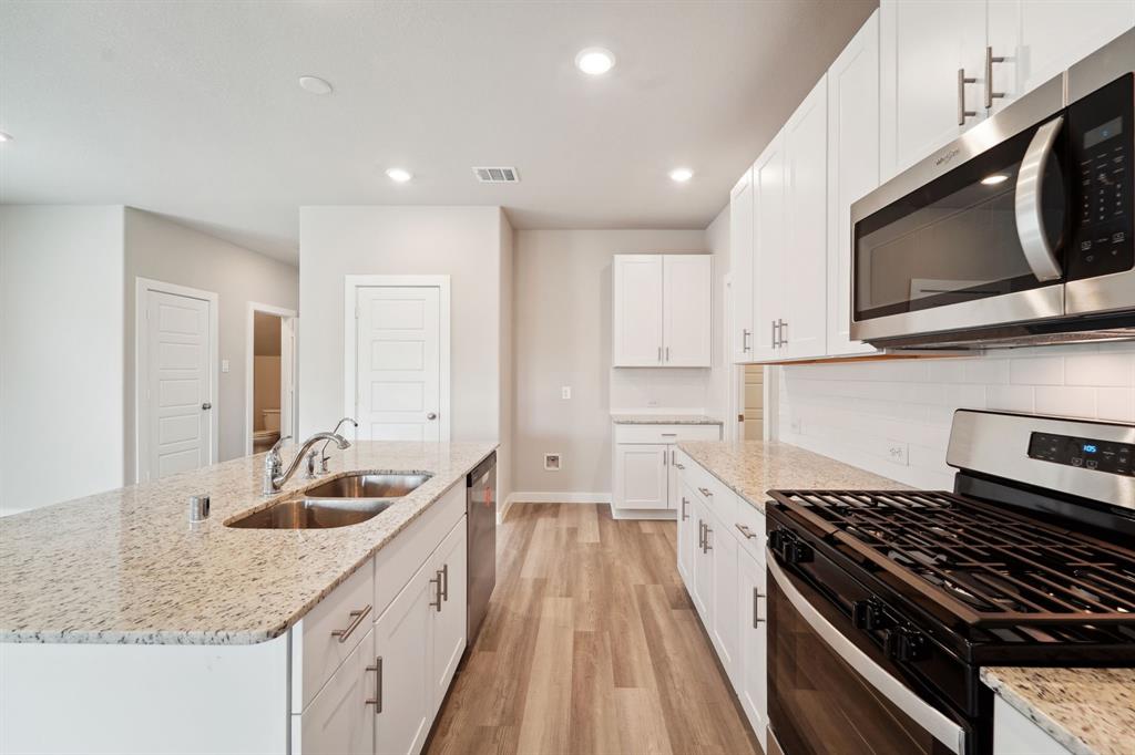 a kitchen with granite countertop a sink and steel appliances