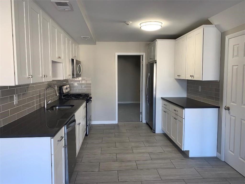 a kitchen with stainless steel appliances granite countertop a sink stove and refrigerator