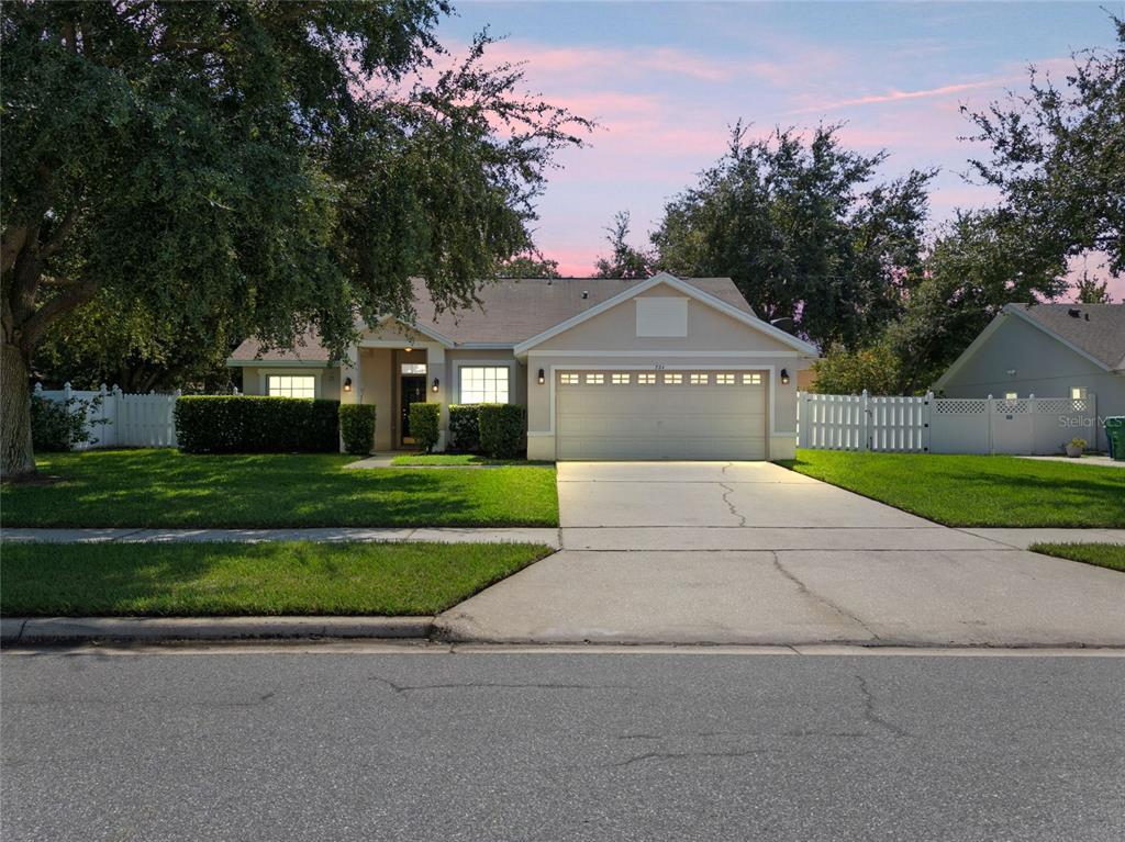 a front view of a house with a garden and trees