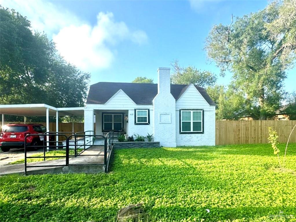 Rear view of house with a lawn and a carport