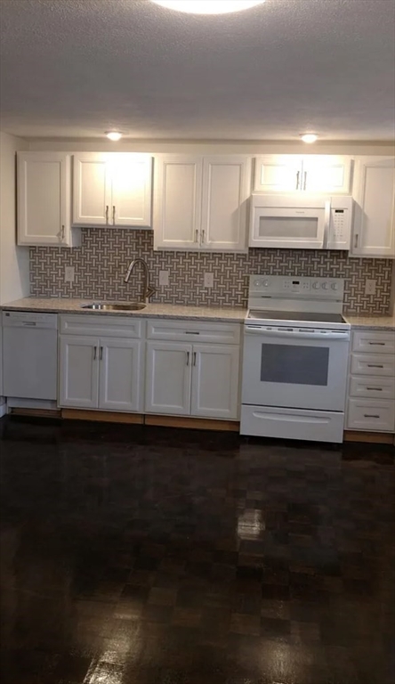 a kitchen with granite countertop a stove a sink and a dishwasher