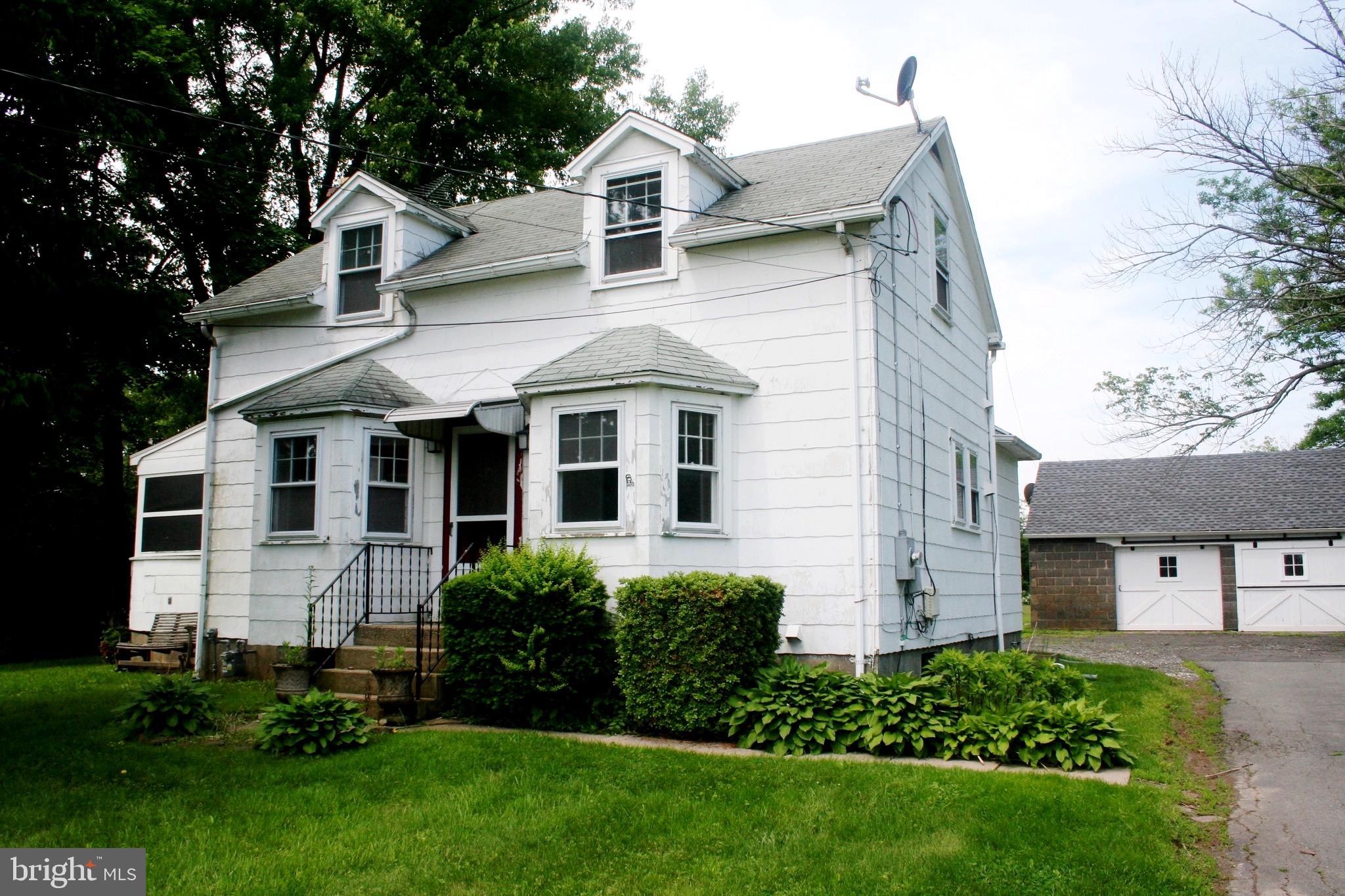 a front view of a house with a garden and plants