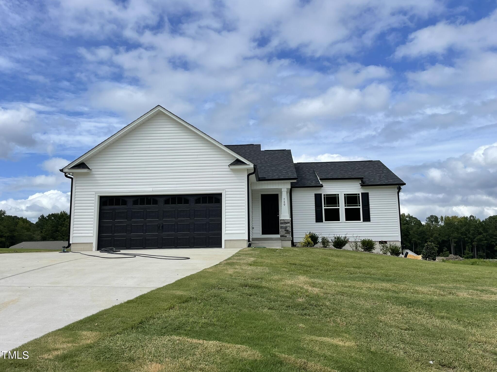 a front view of house with yard and garage