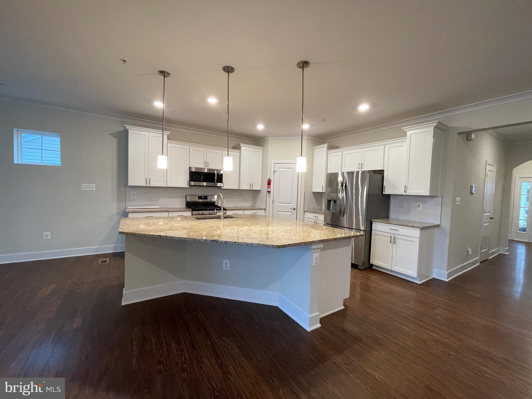 a view of kitchen with stainless steel appliances refrigerator stove microwave and cabinets