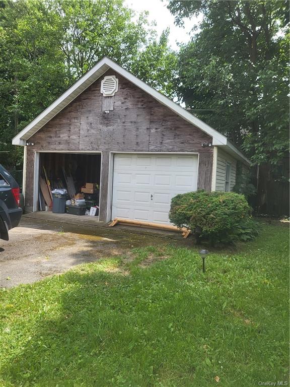 a front view of house with yard and trees in the background