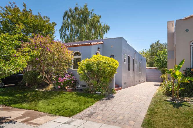 a view of a house with a yard and potted plants