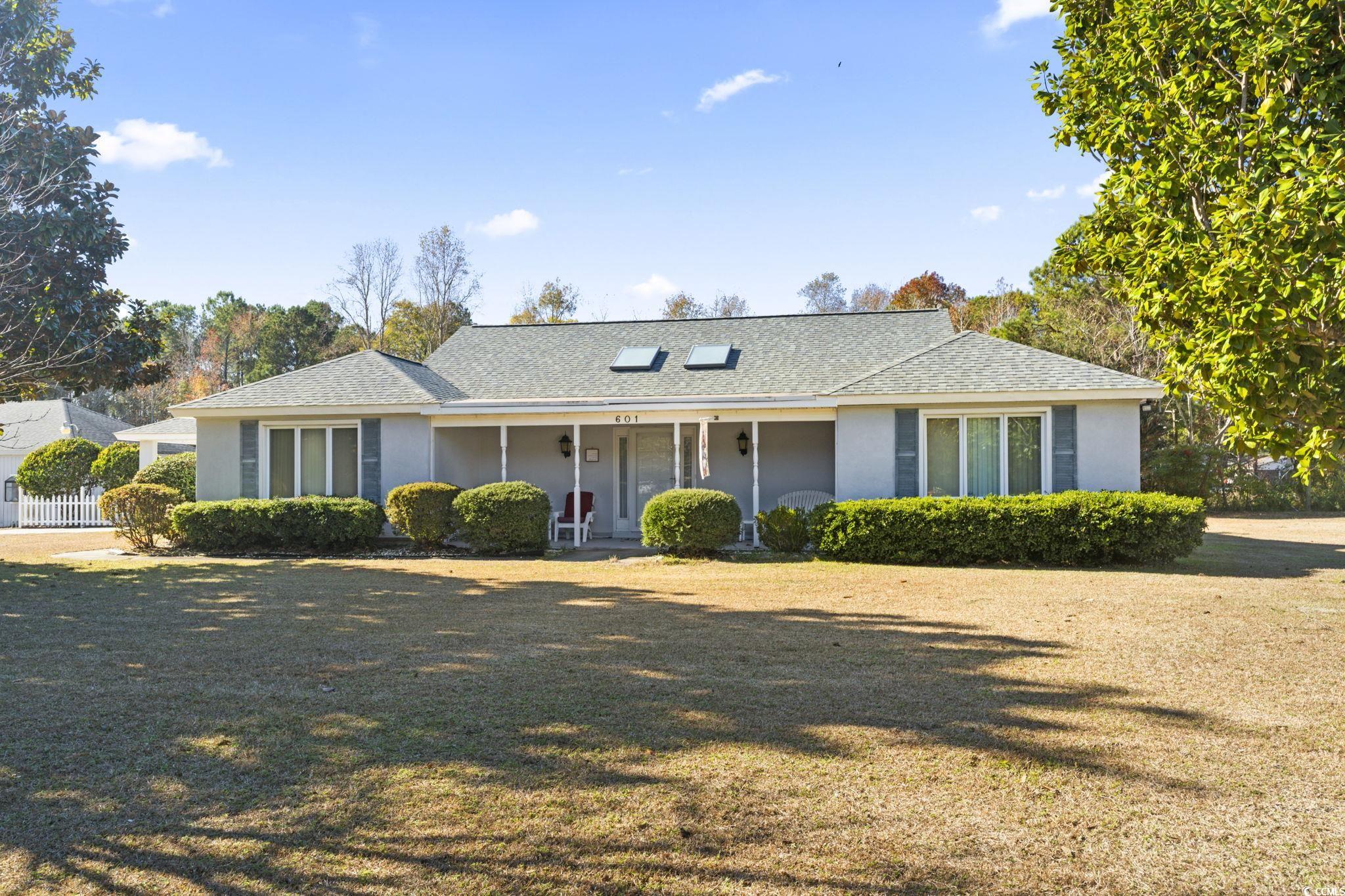 Single story home with a porch and a front yard